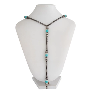Detail of vintage Y-shaped long necklace with silver beads and turquoise accents