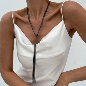 Minimalist Y-shaped multi-layer gunmetal tassel necklace on a model wearing white silk
