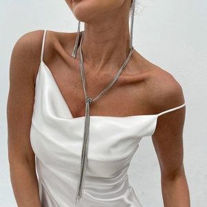 Detail of silver long tassel Y-necklace and matching fringe earrings on a model