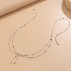 Multi-layer silver metal waist chain with elegant bead detail and bow-shaped pendant design
