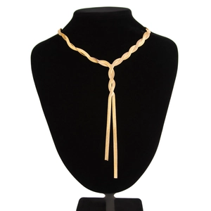Close-up of golden flat snake bone chain necklace with crossover knot design on stand