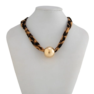 Detail of leopard print fabric necklace with a large polished gold ball pendant on a bust