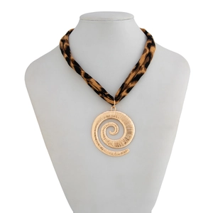 Detail of spiral gold pendant with hammered texture and leopard print fabric strap necklace