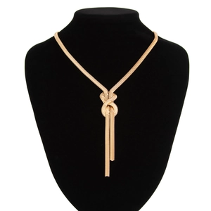Detail of gold snake chain necklace with a central knot and elegant flowing tassels