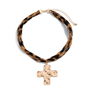 Macro detail of leopard print double layer choker with hammered gold cross pendant