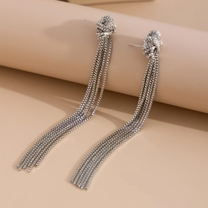 Close-up of silver Y-style fringe tassel earrings with sleek metallic box chains