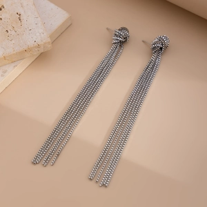 Detail shot of silver braided knot earrings with long flowing box chain tassels