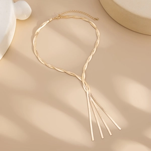 Close-up of golden tassel lariat necklace with dual woven snake chains and sleek metal fringe