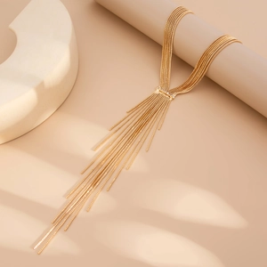 Detailed close-up of golden multi-layer tassel necklace with delicate rhinestone accents