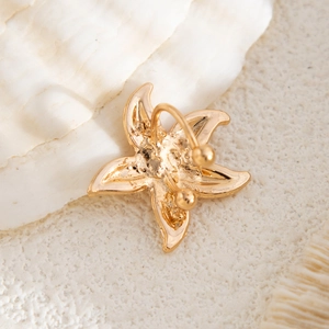 Macro detail of gold flower ear cuff showing the C-shaped clip and polished alloy petals