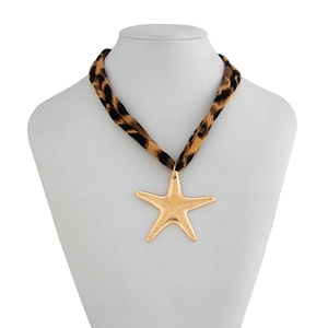 Detail of leopard print fabric strap and textured gold starfish pendant on a white necklace