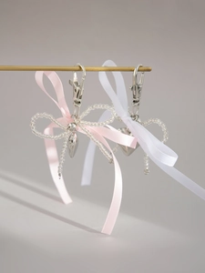 Détail de porte-clés à ruban rose et blanc avec pendentifs en forme de cœur