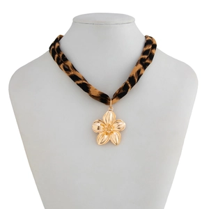 Detail of leopard print fabric cord with golden flower pendant on a white mannequin