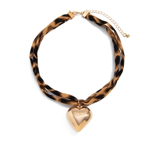 Detail of leopard print fabric choker featuring a polished gold heart-shaped pendant