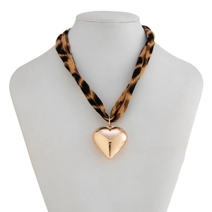 Detail of leopard print fabric cord necklace featuring a polished gold heart pendant