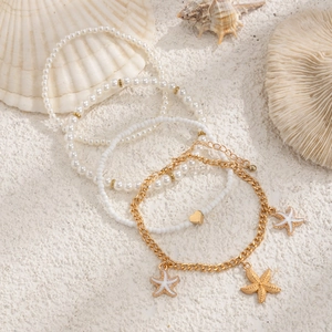 Détails d'un ensemble de 4 bracelets de cheville de plage avec étoiles de mer sur sable