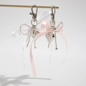 Porte-clés ruban rose et blanc avec pendentif cœur sur un support d'exposition