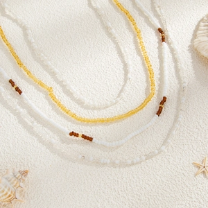 Ensemble de chaînes de taille bohème en perles multicouches sur sable avec coquillages