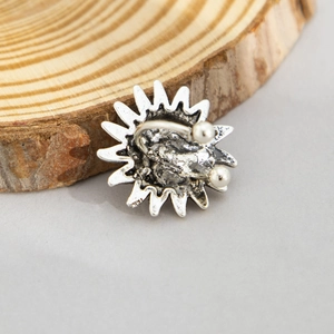 Detail of vintage silver ear cuff with sunflower texture on rustic wood background