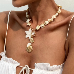 Detail der Boho-Muschelkette mit goldenen Seestern-Anhängern an einem Modell