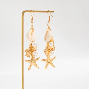 Details von Strand-Ohrringen mit Muschel, Perle, goldener Schildkröte und Seestern