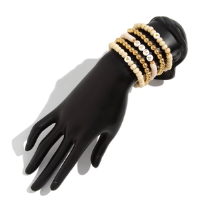 Detail of multi-layered Bohemian bracelet set featuring MAMA beads on a black hand model
