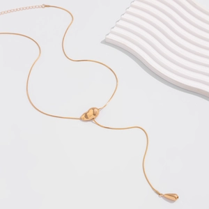 Detailed view of golden snake chain featuring irregular bean and teardrop pendant