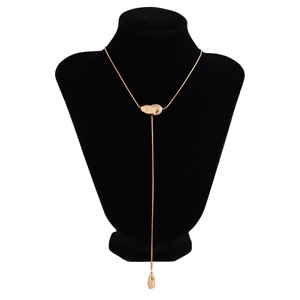 Detail of gold snake chain with heart slider and teardrop pendant on black display neck