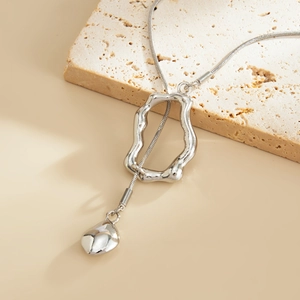 Macro shot of silver liquid metal ring and teardrop pendant on minimalist snake chain