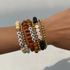 Detail of bohemian MAMA letter beaded bracelets with natural wood and faux pearl accents