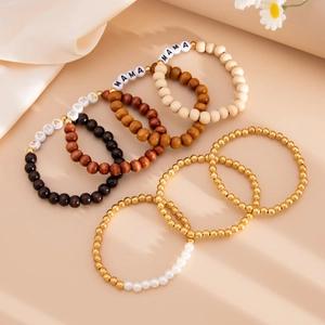 Detail of bohemian wooden beaded bracelets with MAMA letter charms and golden accents
