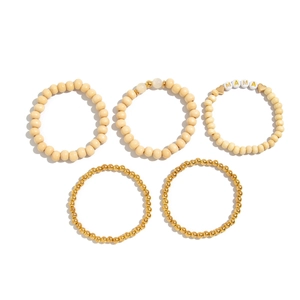 Detail view of five-piece cream and gold beaded bracelet set with MAMA letter charms