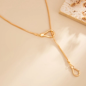 Detail of gold snake chain necklace featuring U-shaped buckles and water drop pendant