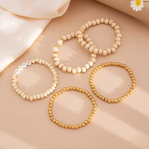 Detail of bohemian stackable beaded bracelet set with golden accents and MAMA letter beads