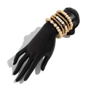 Detail of bohemian stackable beaded bracelets featuring MAMA letters on a black hand model
