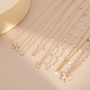 Collection de colliers dorés avec papillons et perles sur support en pierre de luxe