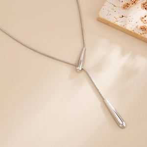 Close-up of silver Y-shaped snake chain necklace featuring elegant double teardrop pendants