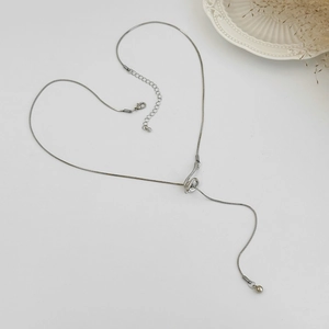 Detailed view of heart-shaped silver snake chain necklace with round bead pendant