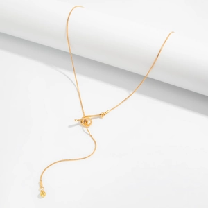 Detail of golden irregular snake chain necklace with teardrop pendant on white stand