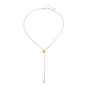 Close-up of golden lariat snake chain necklace with knot clasp and metal ball pendant