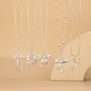 Détails de cinq colliers à pendentif nœud argenté avec différents styles de chaînes