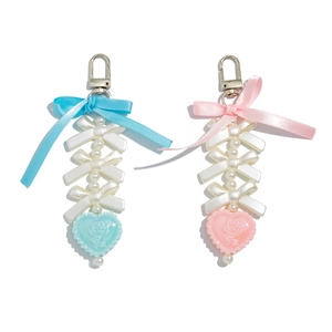 Sweet bow and pearl heart keychain in pink and blue colors on a clean white background