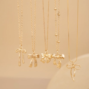 Colliers à pendentif cœur punk dorés avec divers designs de chaînes sur fond beige
