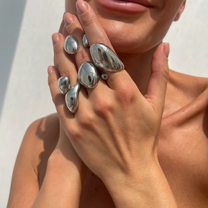 Detailansicht silberner Ringe im Liquid-Metal-Stil mit unregelmäßigem Spiegel-Finish