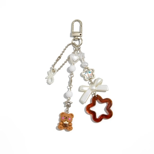 Détail du pendentif ours avec nœud en perles et breloques colorées sur porte-clés