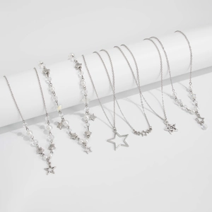 Détails de l'ensemble de colliers étoile et perle argentés sur supports blancs