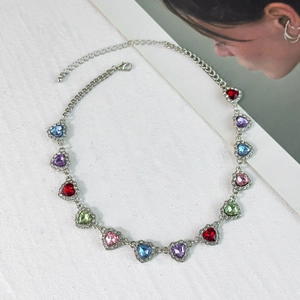 Detailopname van zilveren ketting met kleurrijke kristallen hartjes en een karabijnsluiting