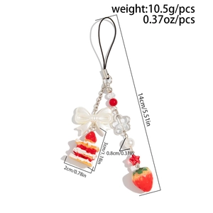 Détail du porte-clés gâteau à la fraise avec nœud blanc et ornements de perles