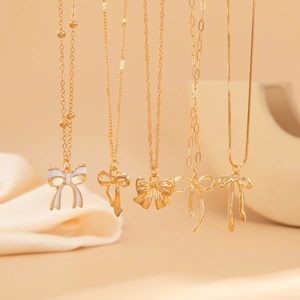 Détail de colliers dorés avec pendentifs nœuds et diverses chaînes élégantes