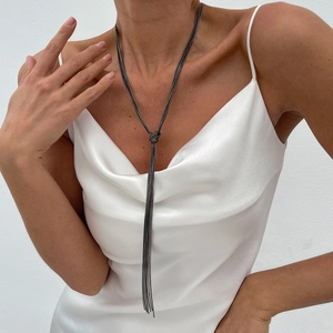 Minimalist gunmetal grey long chain tassel necklace with knot design on white satin dress
